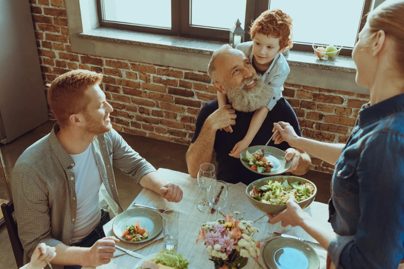 Three generations of a family sharing a meal together around a kitchen table.